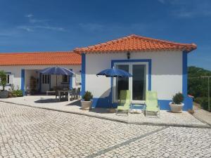ein Haus mit zwei Stühlen und zwei Sonnenschirmen in der Unterkunft Água Rocha in Serra de Mangues