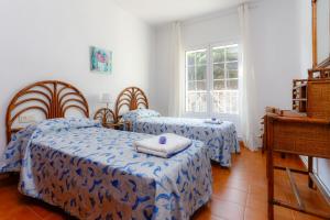 sypialnia z 2 łóżkami i oknem w obiekcie La Marina, casa en playa San Pol de Mar, Barcelona w mieście San Pol de Mar