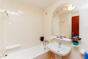 Baño blanco con lavabo y espejo en La Marina, casa en playa San Pol de Mar, Barcelona, en Sant Pol de Mar