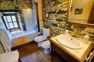 a stone bathroom with a sink and a toilet at Casas da Lexa in Taramundi +23 photos