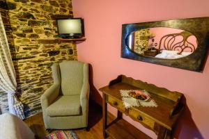 a room with a chair and a mirror and a table at Casas da Lexa in Taramundi