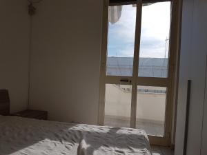 - une chambre avec un lit et une fenêtre ouverte dans l'établissement Apartment Colaianni, à Torre San Giovanni