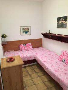 オルソラにあるApartamentos Los Vientos (Apto 1)のベッドルーム1室(ピンクのシーツとテーブル付きのベッド2台付)