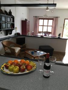 un plato de fruta en una barra con una botella de vino en Apartamentos Los Vientos (Apto 1), en Orzola