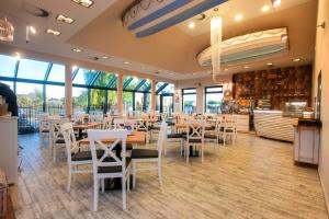 a dining room with tables and chairs and windows at Villa Fenix in Ustronie Morskie