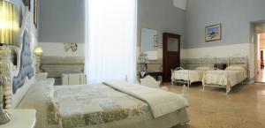 - une chambre avec 2 lits et un miroir dans l'établissement B&B Dimora Muzio and Restaurant, à Gallipoli