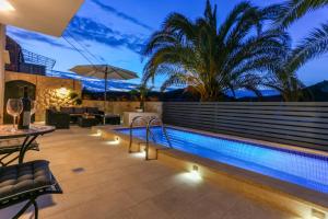 an outdoor swimming pool with a table and chairs at Villa Capitis in the Centre - Private Pool Villa & Balcony Apartment with Spectacular View-No Pool in Hvar