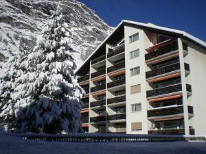 ein Gebäude vor einem schneebedeckten Berg in der Unterkunft Haus Sonnmatt in Zermatt