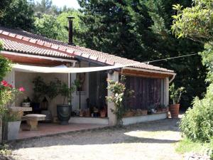 une petite maison avec un parasol blanc dans une cour dans l'établissement Mazet du C'riquet, à Nîmes