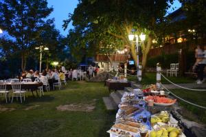 a table filled with food and people sitting at tables at Heybeli Hotel in Mudanya +54 photos