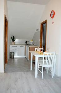 a kitchen with a white table and white chairs at Villa Violić in Zaton