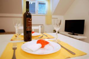 a bottle of wine and a plate on a table at Villa Violić in Zaton