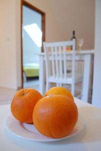two oranges sitting on a plate on a table at Villa Violić in Zaton