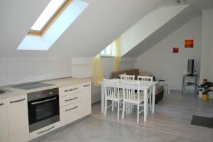 - une cuisine avec des placards blancs et une table dans une pièce dans l'établissement Villa Violić, à Zaton