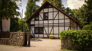 Biały i czarny dom z kamienną ścianą w obiekcie Apartament Antique w mieście Karpacz