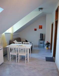 a dining room with a white table and chairs at Villa Violić in Zaton