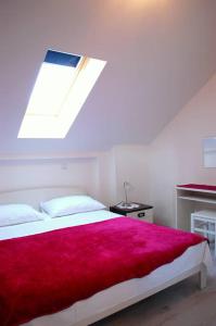 a bedroom with a large bed with a red blanket at Villa Violić in Zaton