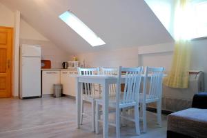 a white table and chairs in a kitchen with a refrigerator at Villa Violić in Zaton