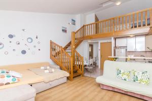 a living room with a staircase and a couch at Apartments Garmaz in Podgora