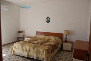 una camera con letto, tavolo e orologio di B e B CASA DA PINA a Ragusa