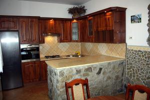a kitchen with wooden cabinets and a granite counter top at Dom Aga Bieszczady 10 osobowy in Bukowiec