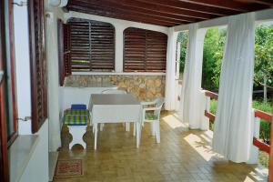ein Esszimmer mit einem Tisch und Stühlen auf einer Veranda in der Unterkunft Apartments Lovor in Silba