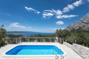 a swimming pool with a view of the ocean at Holiday Home Chill Zone in Baška Voda