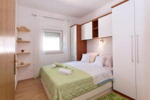 a small bedroom with a bed and a window at Holiday Home Chill Zone in Baška Voda +47 photos
