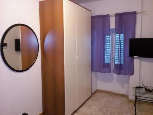 a mirror and a cabinet in a room at Casa Elsa in Biassa