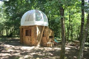 une cabane dans les arbres avec un toit en dôme dans les bois dans l'établissement Ô Bois Dormant, à Lempzours