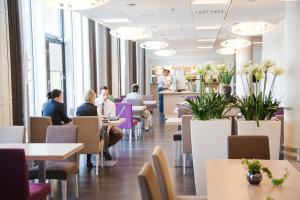 un grupo de personas sentadas en mesas en un restaurante en Norlandia Tampere Hotel, en Tampere