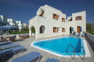 Ein Swimmingpool vor einem Haus mit Stühlen in der Unterkunft Kelenis Apartments in Karterados