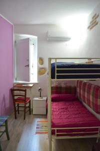 カリアリにあるAbbardente appartamento in centroのベッドルーム1室(赤いマットレス付きの二段ベッド1組付)