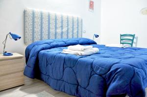カリアリにあるAbbardente appartamento in centroのベッドルームに青いベッド1台(タオル付)
