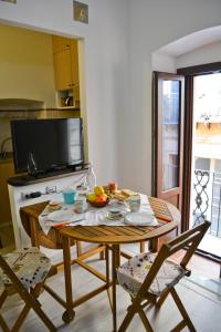 a table and chairs in a kitchen with a television at Abbardente appartamento in centro in Cagliari