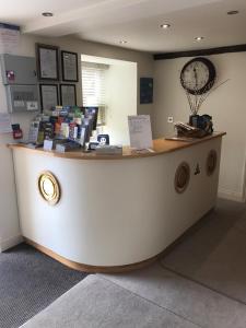 a counter in a store with a clock on the wall at Porthole Suites in Saint Aubin