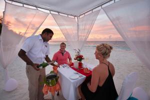 a group of people standing around a table on the beach at Adaaran Club Rannalhi - All Inclusive - 45 Minutes away from Male by Speedboat in South Male Atoll