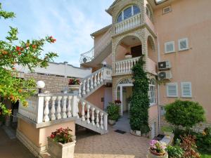 a large house with a staircase in front of it at Apartments Panorama view Zeljko Scerbe in Rab