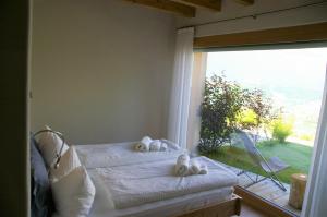 a bedroom with two beds and a large window at Agriturismo Verdecrudo in Caldonazzo