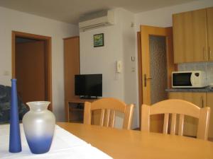 Apartment Gaspercic في بوفيك: طاولة مع إناء جالس فوق طاولة