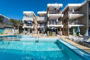 a hotel with a swimming pool in front of a building at Apartamentos El Paseo in Playa del Ingles