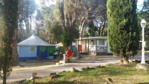 a person sitting in front of a blue and white building at Camping la Croix du Sud in Saint-Tropez