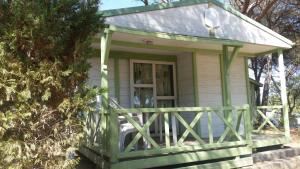 a small green house with a porch at Camping la Croix du Sud in Saint-Tropez