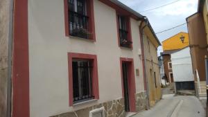 - un bâtiment blanc et rouge avec des fenêtres et des fleurs dans l'établissement Casa fonte da pena, à Rinlo