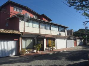 un edificio rojo y blanco con muchas ventanas en Pousada La Lampara, en Cabo Frío