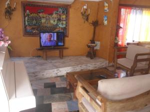 sala de estar con TV sobre una mesa de madera en Pousada La Lampara, en Cabo Frío