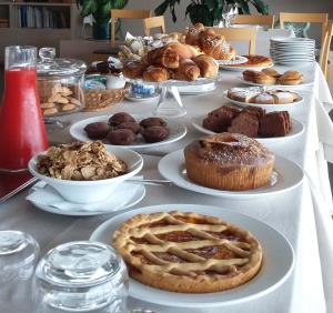 a table full of different types of pastries and pies at Hotel Grecale in Porto Cesareo