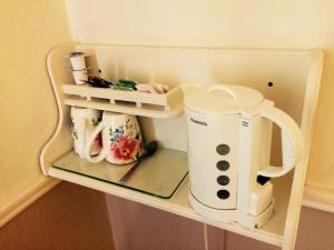 a small refrigerator with a tea kettle on a shelf at Clai Ban in Kilronan