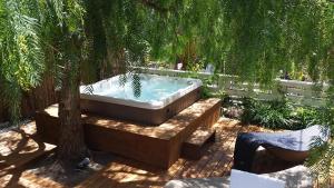 a hot tub in a garden with a tree at Hotel Corallo in Pomonte