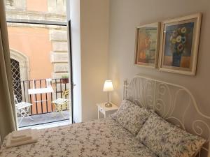 a bedroom with a bed and a view of a balcony at SanBiagio, 25 Guesthouse in Naples
